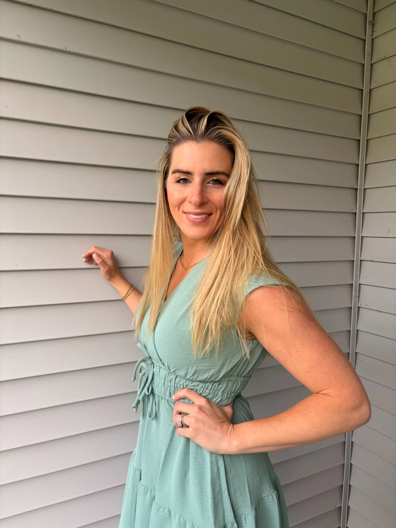 Ashley smiling in a sage-green outfit